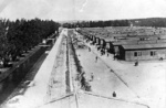 KL Dachau – bendras barakų, kuriuose gyveno kaliniai, vaizdas, spygliuotos vielos tvora, per kurią ėjo aukštos įtampos elektros srovė, kaliniai šalia barakų; 1945 m. balandis (IPN)